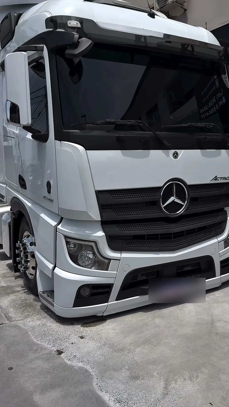 Caminhão Mercedes Actros branco de frente, no pátio