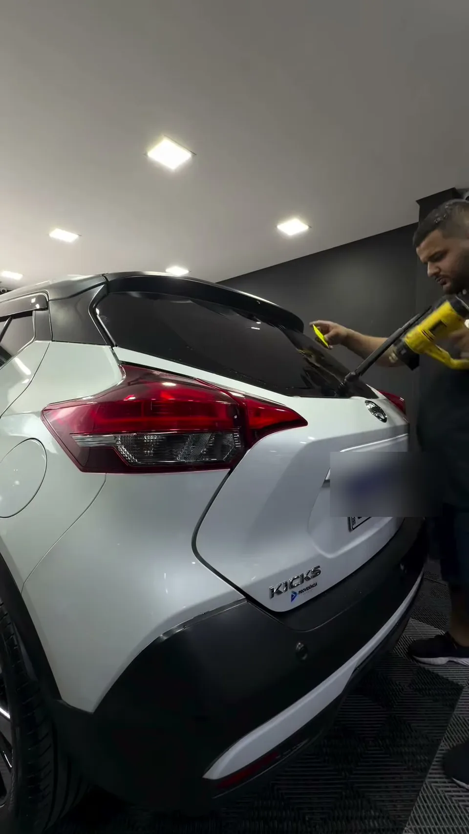 Nissan Kicks branco no estúdio da Black Films, placa borrada